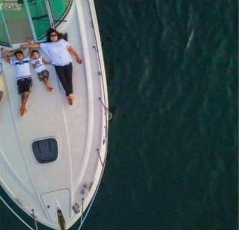 Aerial view of a family relaxing on a yacht deck in Goa